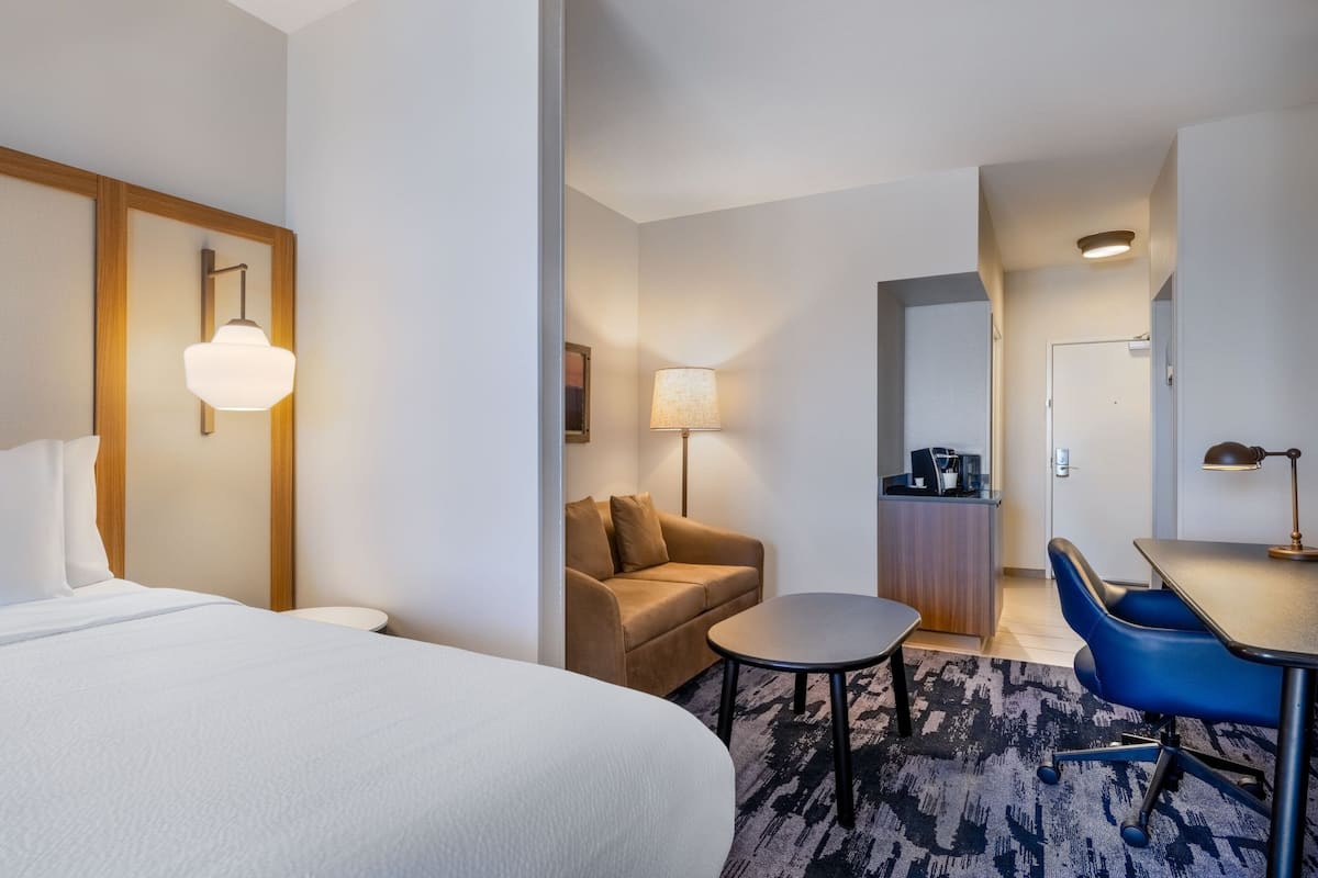 Une chambre d’hôtel avec un lit, un canapé, un bureau et une chaise.