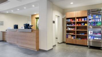A reception area with a wooden counter, a vending machine, and a self-service kiosk.