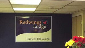 Señal de Redwings Lodge con logotipo y nombre del lugar.