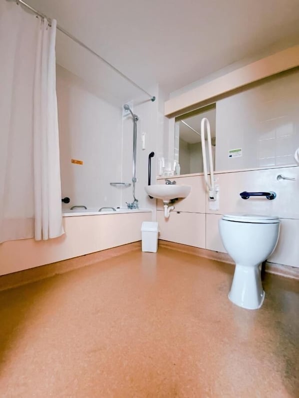 Un baño moderno con inodoro blanco, lavamanos y ducha.