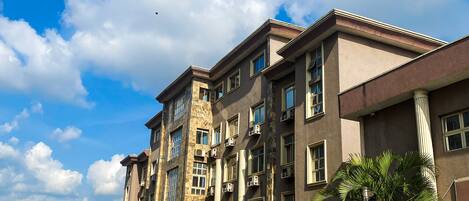 A multi-story building with a parking lot in front.