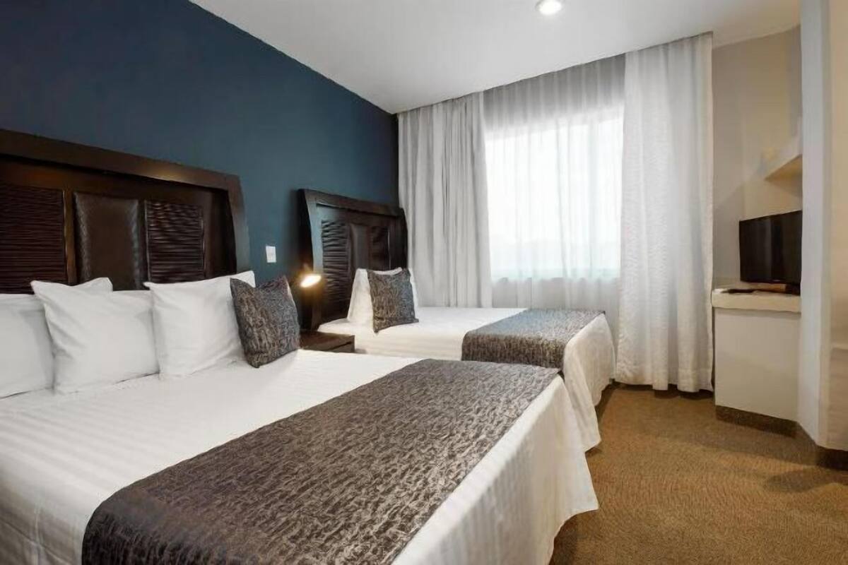 Minibar, escritorio, tabla de planchar con plancha y ropa de cama