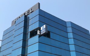 Un hotel con fachada azul moderna y un cartel que indica que pertenece a la cadena hotelera Best Western.