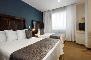 Minibar, escritorio, tabla de planchar con plancha y ropa de cama 