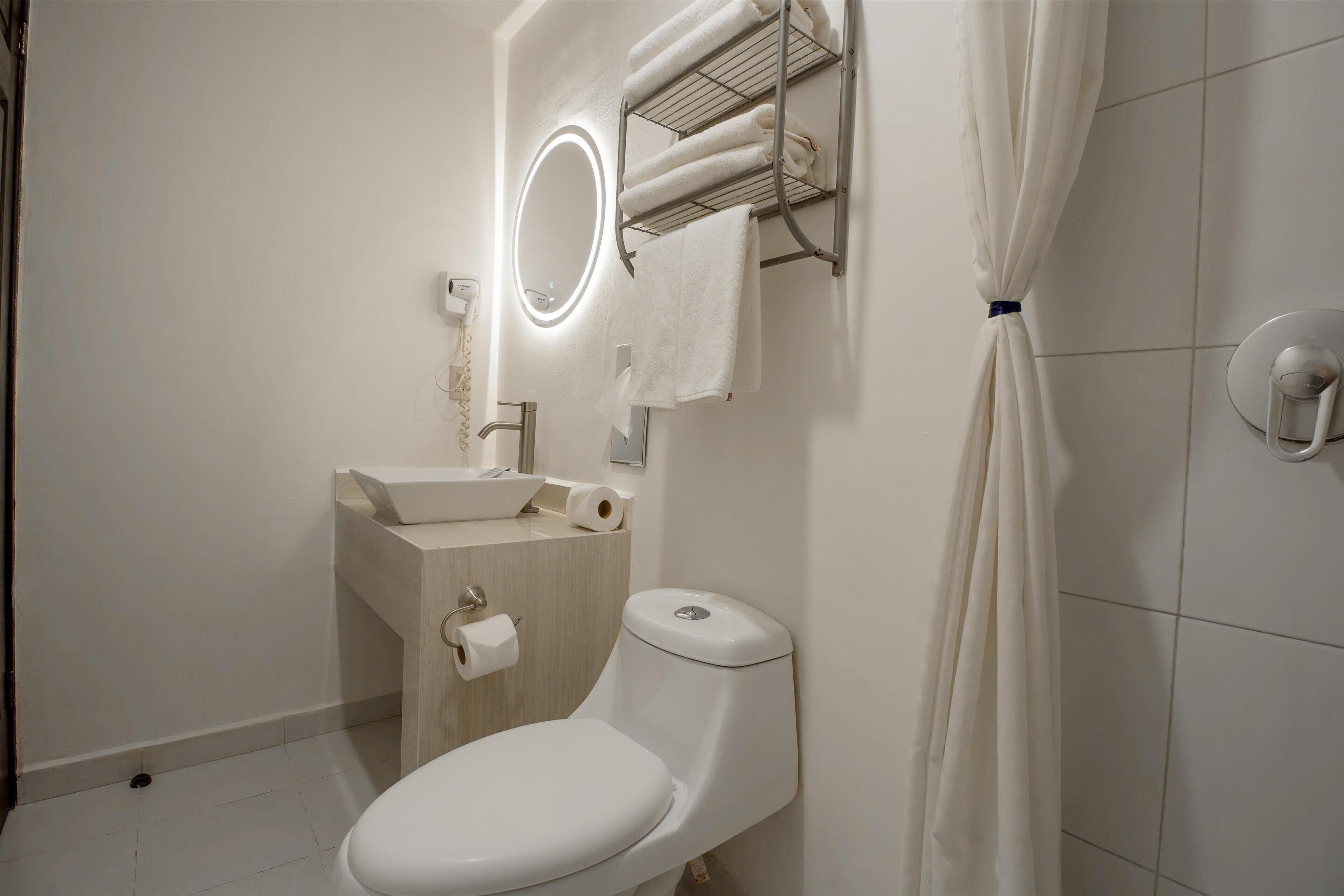 Ein Badezimmer mit Toilette, Waschbecken und Handtuchhalter.