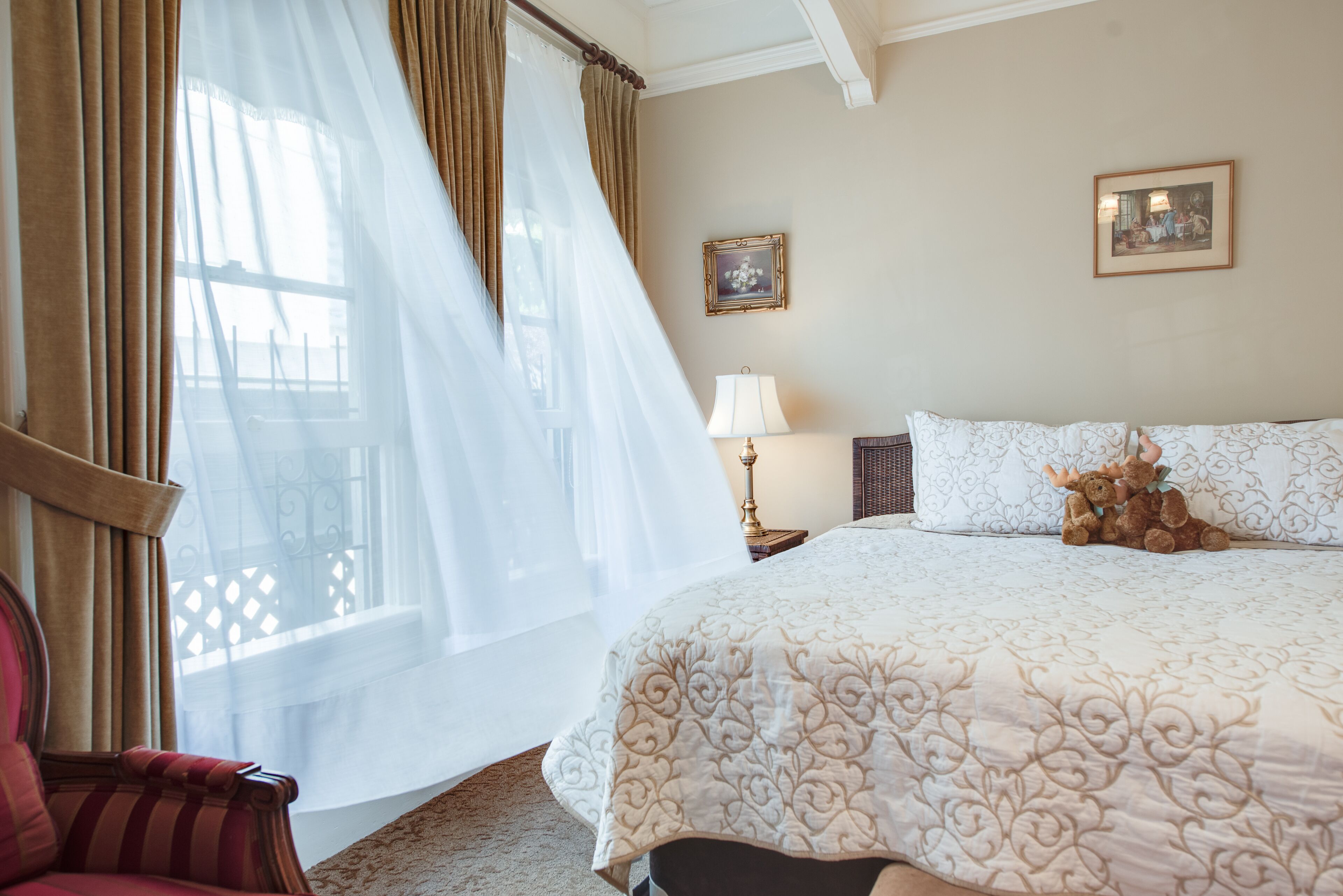 Une chambre d’hôtel avec un grand lit, une chaise, une lampe et un tableau au mur.