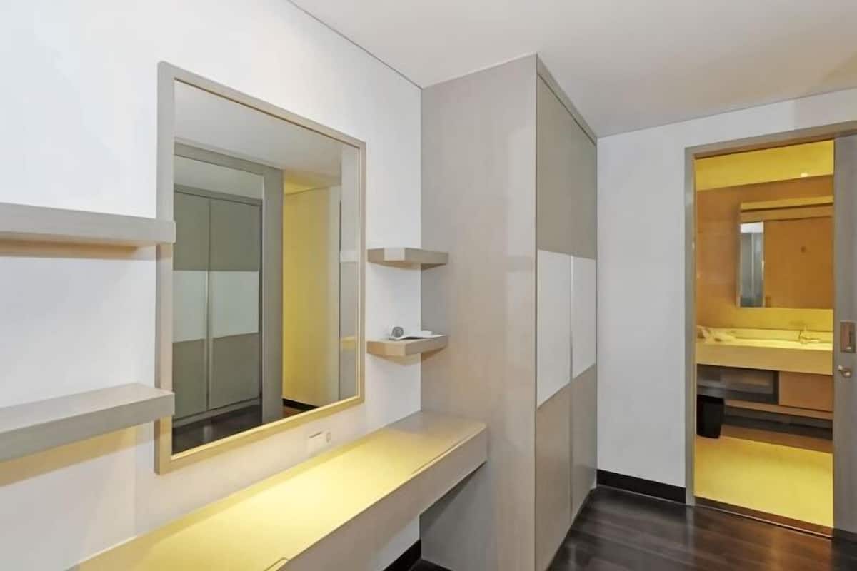 Un baño moderno con un espejo grande, tocador y zona de ducha.