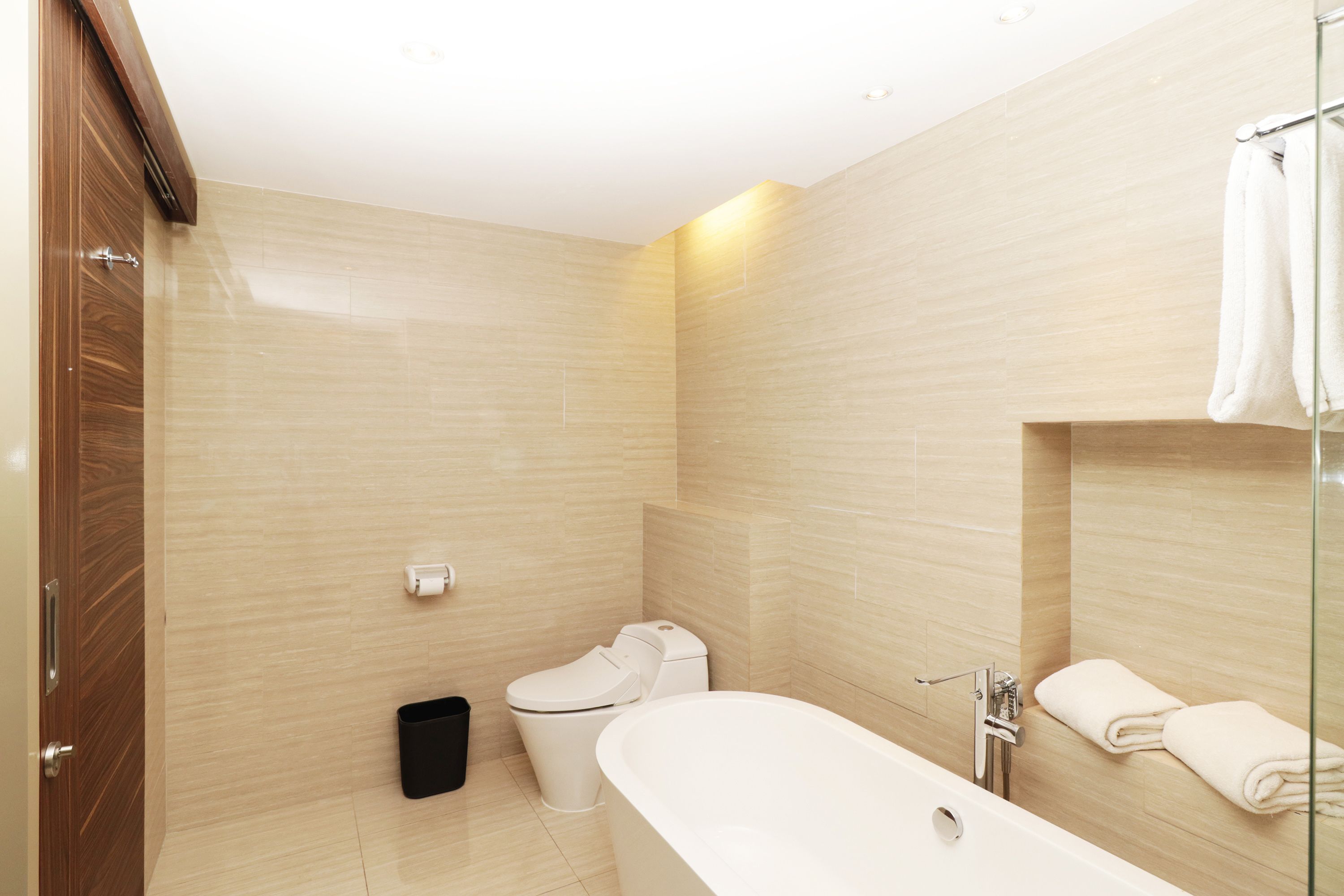 A modern bathroom with a toilet, bidet, and bathtub.