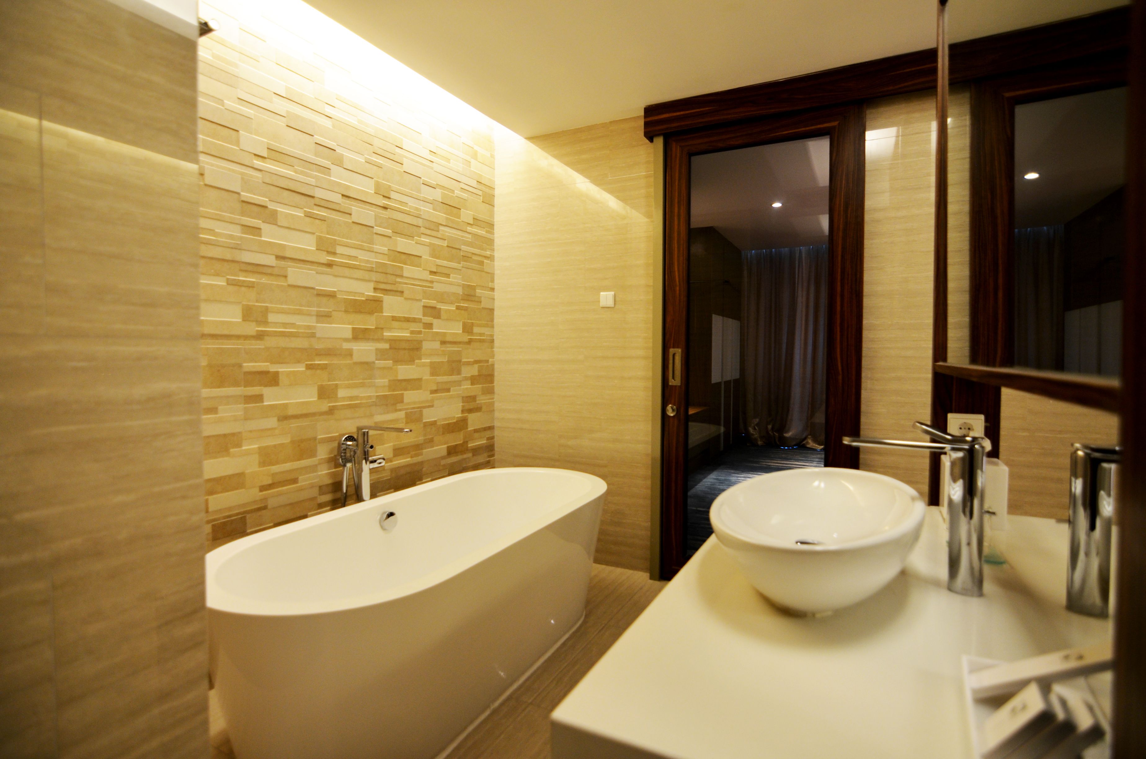 A modern bathroom with a freestanding bathtub, a large sink, and a mirror above the sink.
