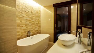 A modern bathroom with a freestanding bathtub, a large sink, and a mirror above the sink.