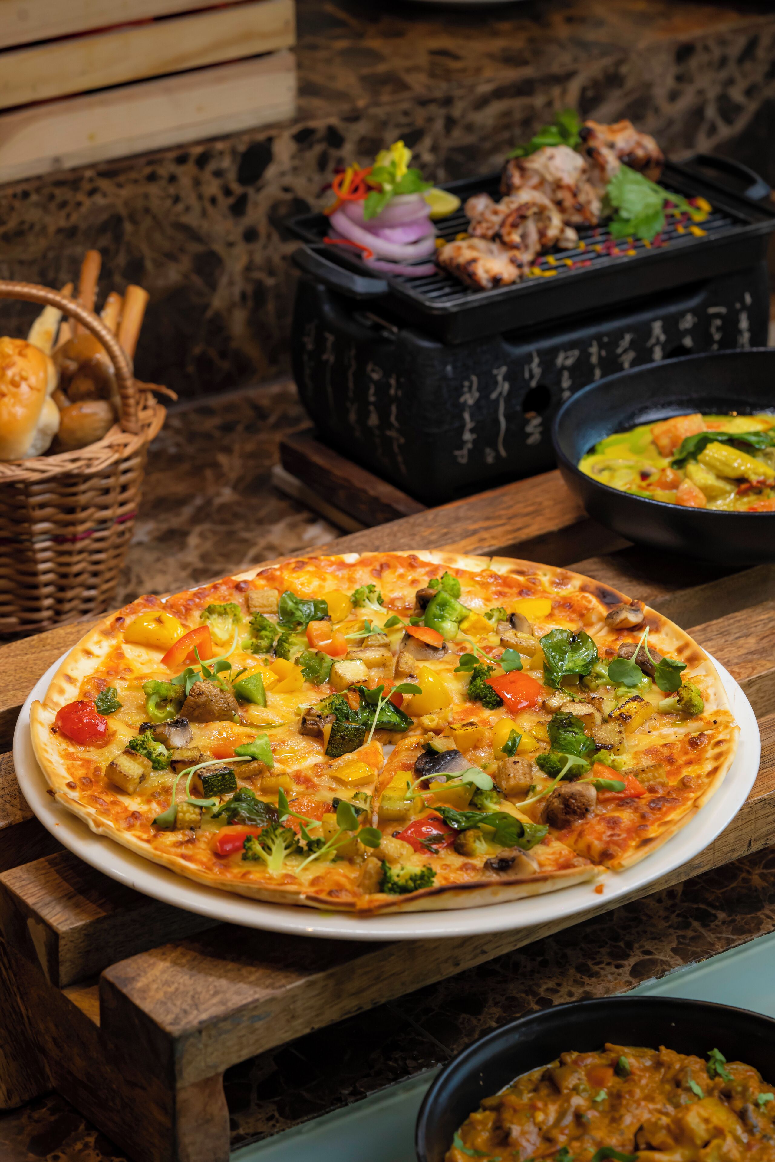 Une pizza garnie de divers ingrédients, posée sur une table en bois.