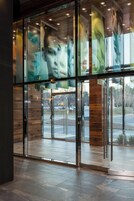A modern building entrance with glass doors and a wooden interior.