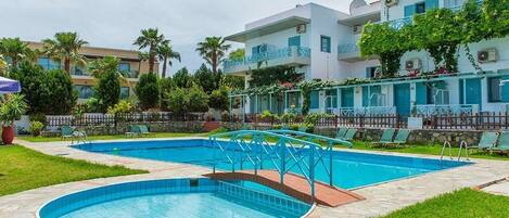 Een seizoensgebonden buitenzwembad en parasols bij het zwembad