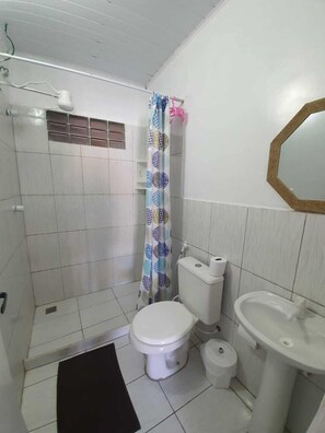 A bathroom with a toilet, bidet, sink, and shower area. - Canema Pousada (Arraial do Cabo)