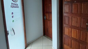 A hallway with a door labeled "Pousada Fernandes" and a keypad lock. - Pousada Fernandes (Arraial do Cabo)