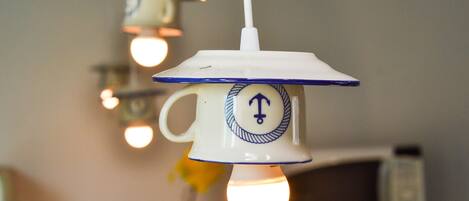 Two hanging light fixtures with a nautical theme, one with a visible light bulb.