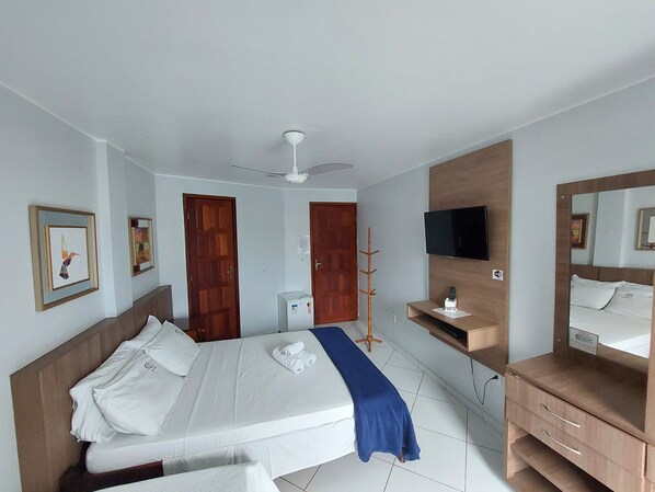 Une chambre d’hôtel équipée d’un lit, d’une télévision, d’un bureau et d’une armoire.