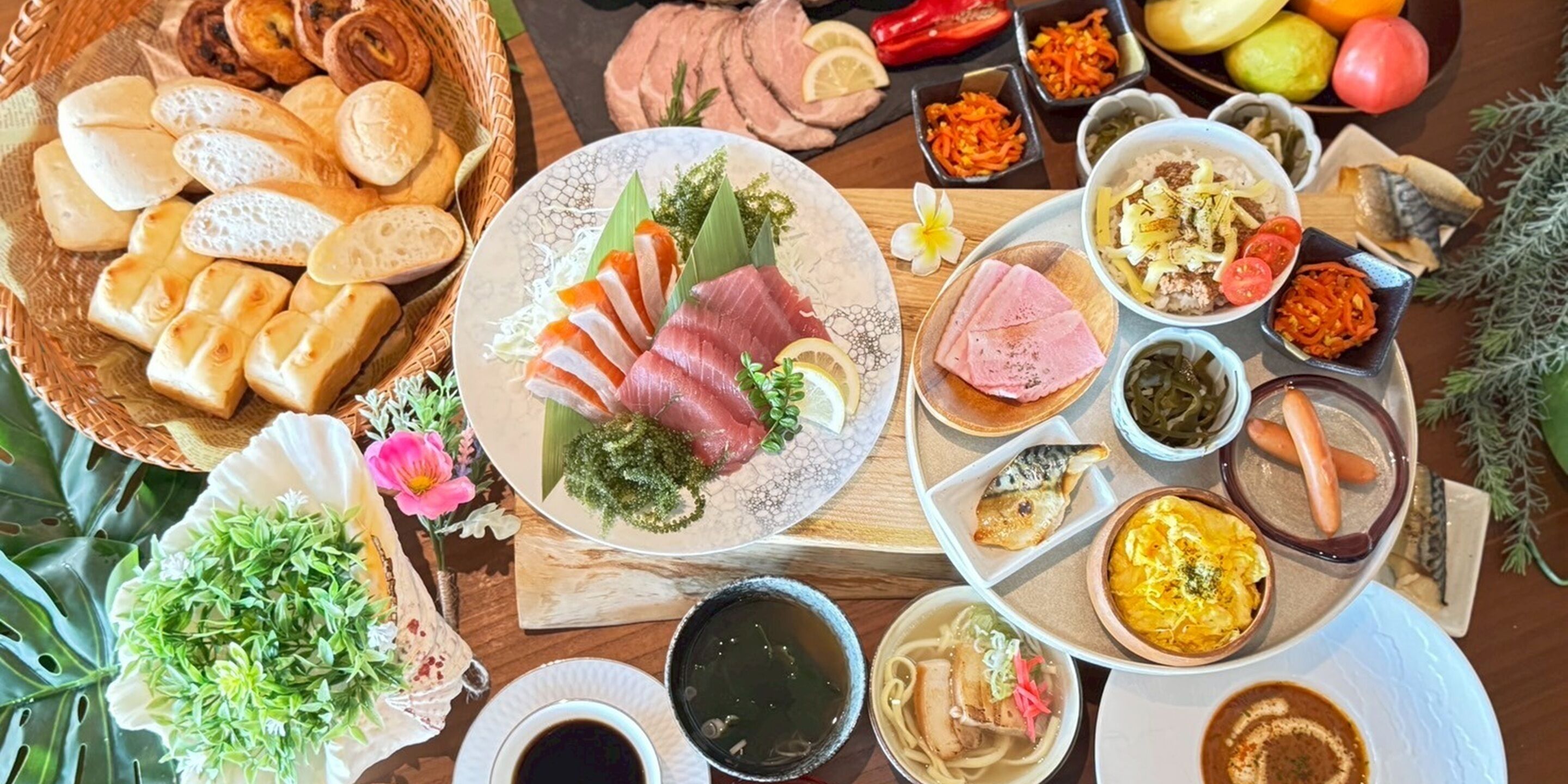 A variety of food items including sashimi, bread, and vegetables on a table.