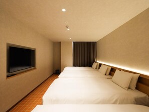 A hotel room with a large bed, a television mounted on the wall, and a curtain.
