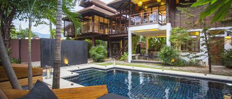 A poolside area with lounge chairs and a wooden deck.