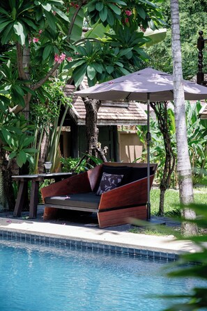 Una piscina al aire libre, tumbonas