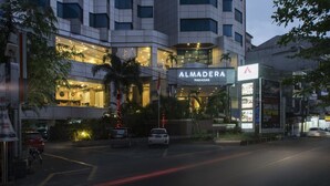A modern hotel with a prominent 'ALMEDERA' sign, multiple floors, and a well-lit entrance. - Almadera Hotel Makassar (Makassar)