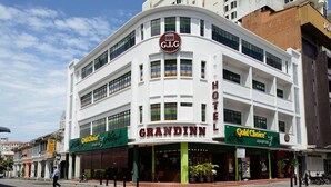 Un hôtel avec une enseigne bien visible portant le nom « GRANDINN », un logo « G.I.G » et un restaurant classé « Gold Choice ».