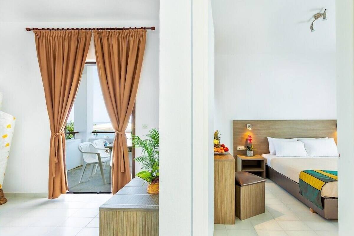 Ein Hotelzimmer mit Bett, Nachttisch und Blick auf den Balkon.