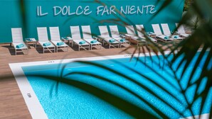 A poolside area with lounge chairs and a sign reading "IL DOLCE FAR NIENTE". - Plaza Santa Ponsa Boutique Hotel - Adults Only (Calvia)