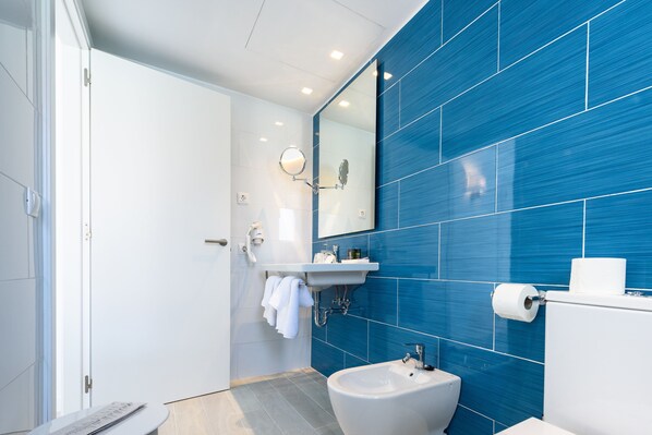 A modern bathroom with a bidet, sink, and mirror. - Plaza Santa Ponsa Boutique Hotel - Adults Only (Calvia)