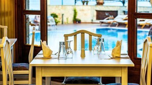 Mesa para dos con vistas a una piscina y al mar.