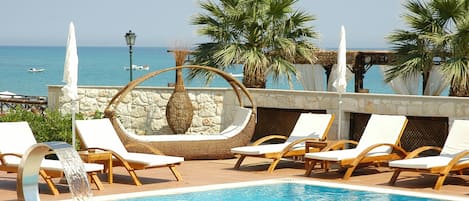 Piscine extérieure, parasols de plage, chaises longues