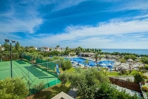 Un complexe hôtelier doté d’une grande piscine, de courts de tennis et offrant une vue sur la mer.