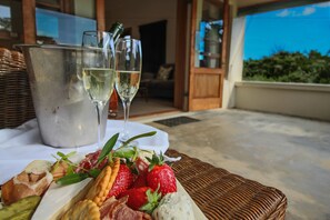 A table with a charcuterie board, two glasses of white wine, and a metal bucket. - Dune Ridge Country House (Saint Francis Bay)