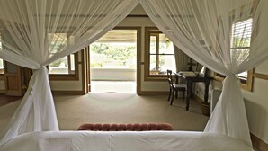 A bedroom with a bed, a desk, and a chair. There are windows with curtains. - Dune Ridge Country House (Saint Francis Bay)