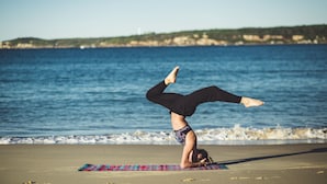 A person performing a handstand on a beach with a view of the sea and distant land. - Dune Ridge Country House (Saint Francis Bay)