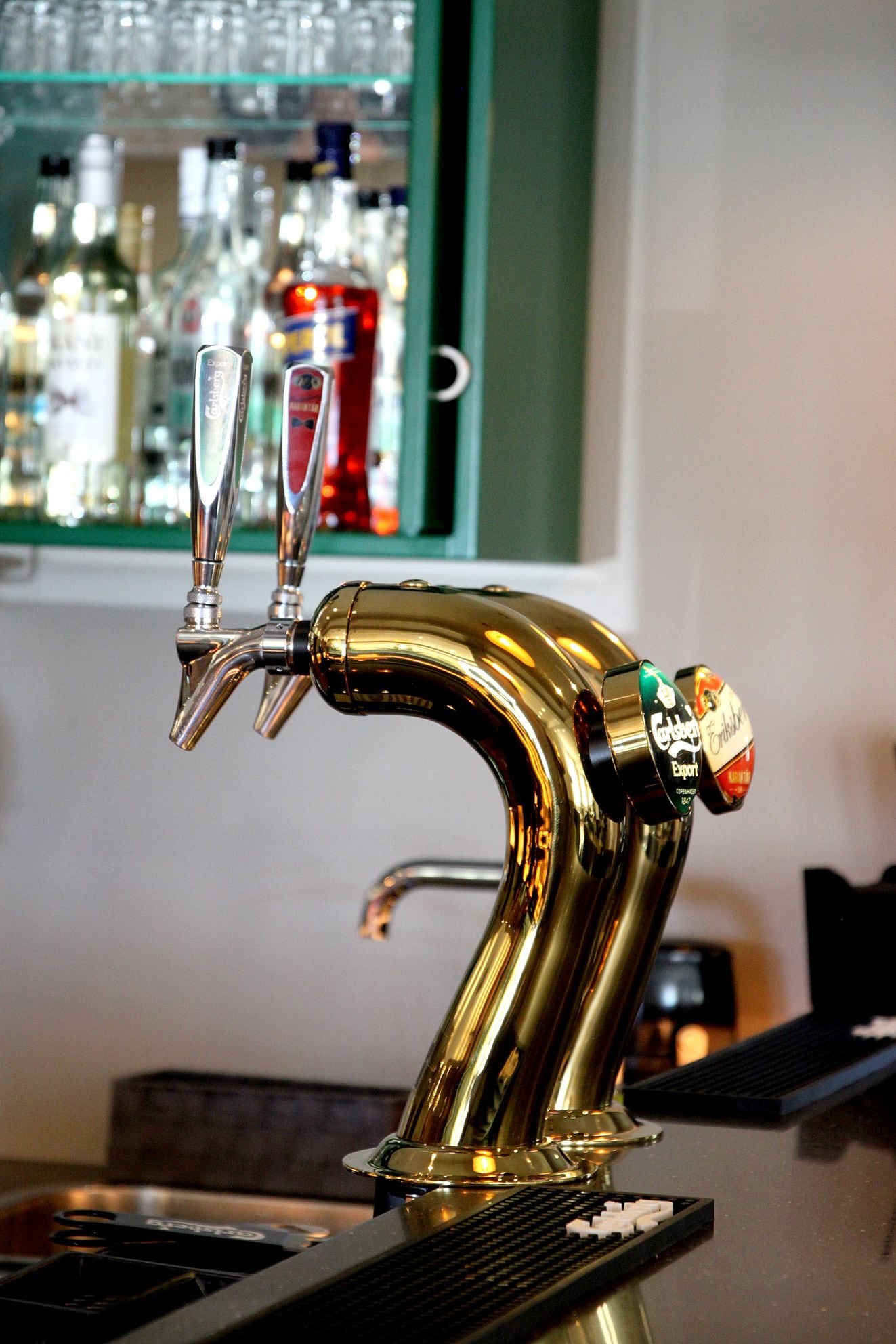A gold-colored tap with two spouts and a label indicating 'Golden Export' beer.