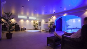 A spacious indoor area with a pool, seating, and potted plants. - Hotell Nordic (Norrköping)