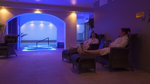 A spa area with two reclining chairs, a small pool, and a view of the sea. - Hotell Nordic (Norrköping)