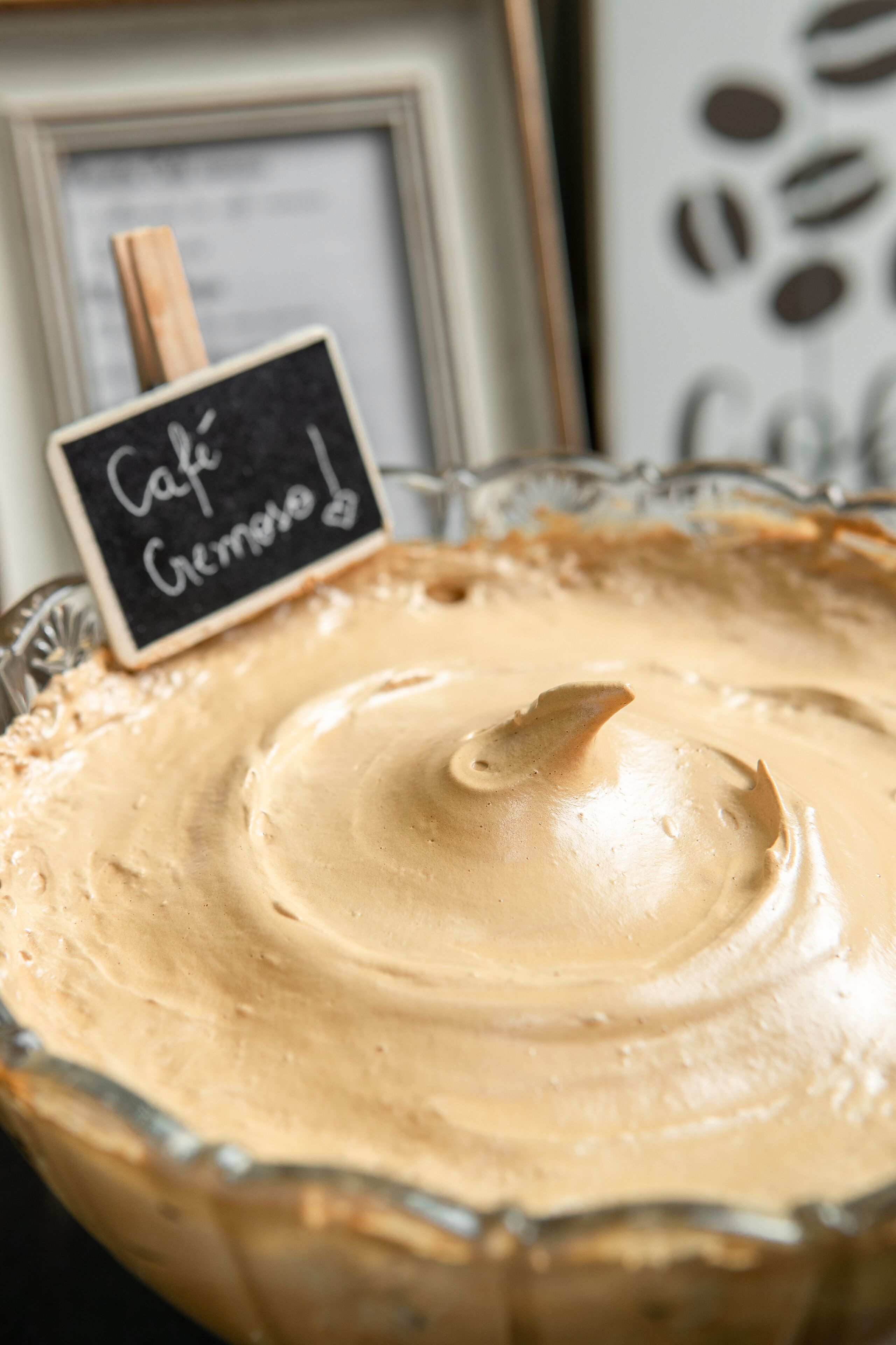 A bowl of creamy dessert with a sign that reads "Cafe Cremino".