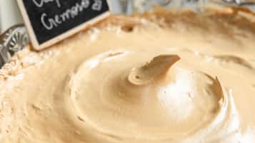 A bowl of creamy dessert with a sign that reads "Cafe Cremino".