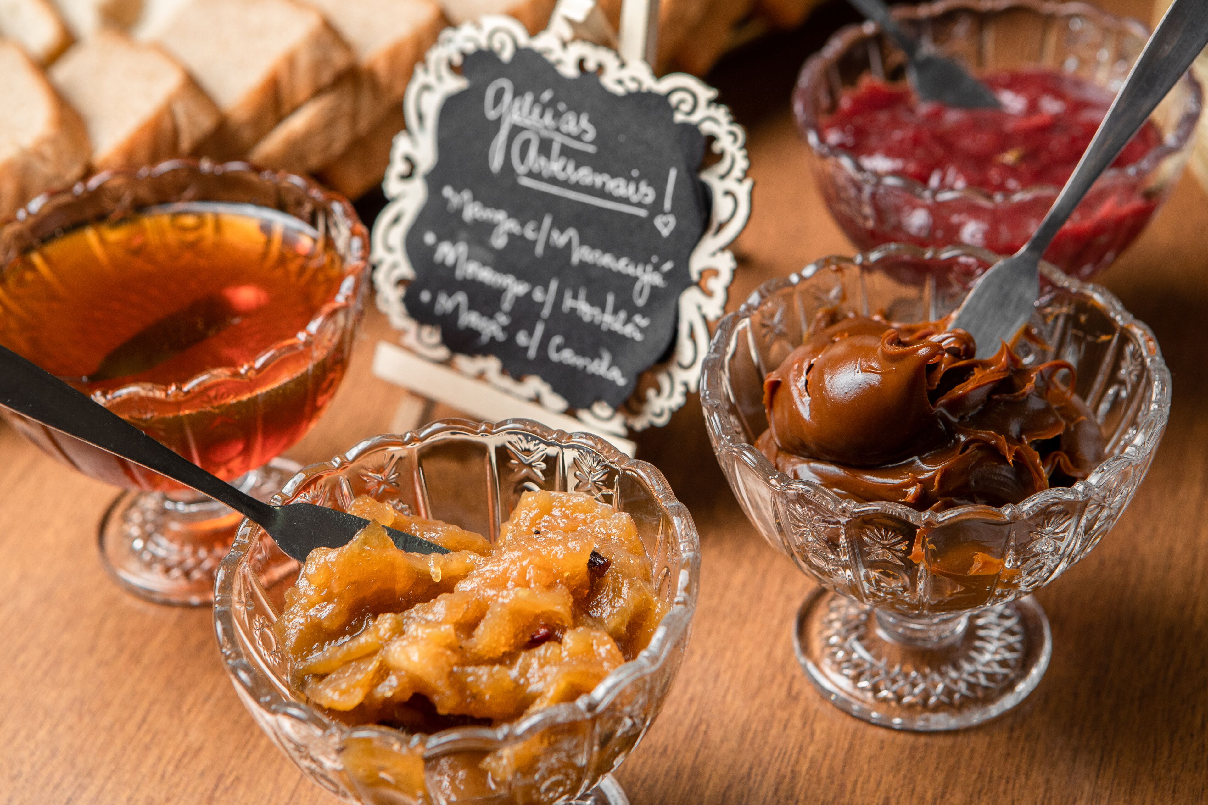 Tres tazones de vidrio con diferentes alimentos sobre una mesa de madera.
