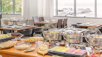 Un tavolo da buffet con diversi cibi e contenitori di vetro trasparente.
