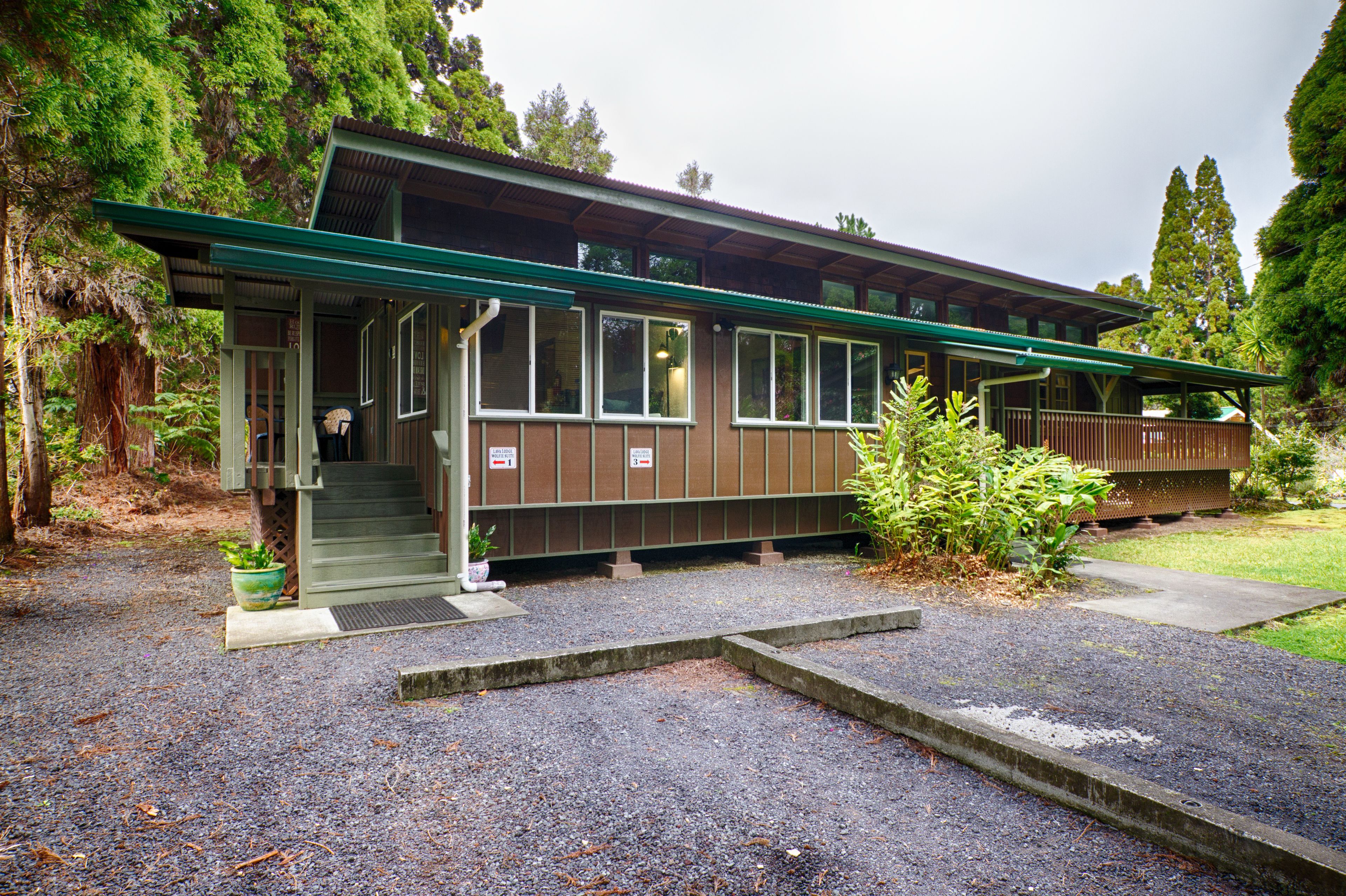 A two-story building with a green roof and a covered porch.