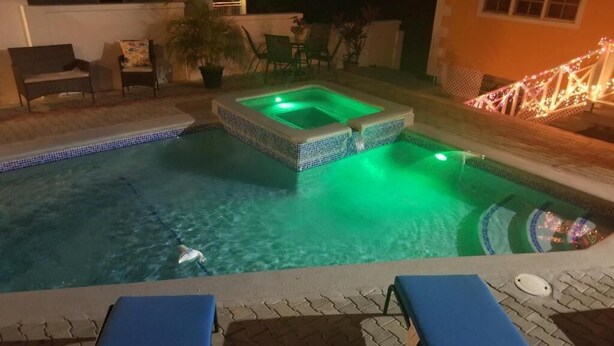 A swimming pool with a hot tub, lounge chairs, and a small deck area. - Faith's Villa of Tobago (Scarborough)