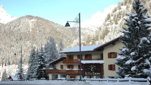 A snow-covered building named "Villa Emma" with a balcony and a signboard. - IHR Hotel Villa Emma (Canazei)