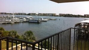 A marina with boats docked, a clear sky, and a view of buildings in the distance.