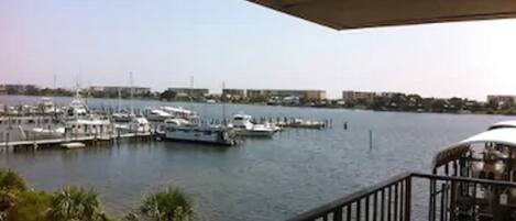 Puerto deportivo con barcos amarrados, cielo despejado y vista de edificios al fondo.
