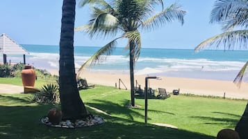 Na praia, espreguiçadeiras, guarda-sóis, toalhas de praia