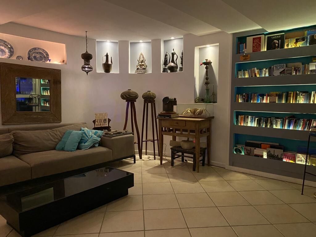 A living room with a sofa, coffee table, and a bookshelf filled with books.